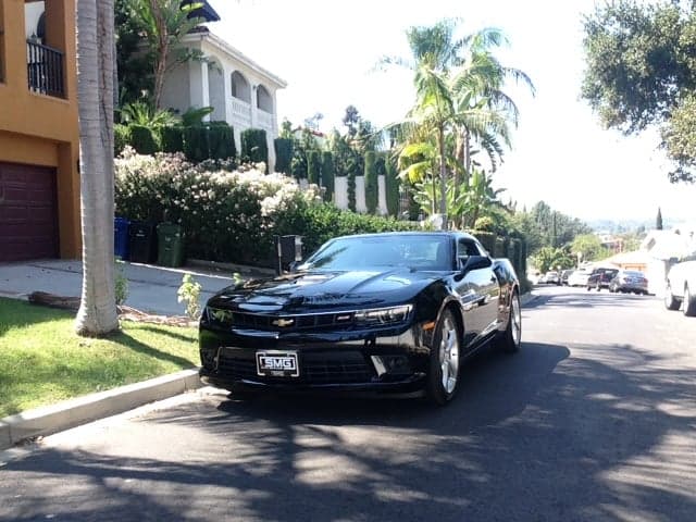 Black Chevrolet Camaro with an SMG plate frame parked on a Los Angeles street